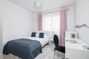 a white bedroom with a bed and a desk at Cracow Prądnik Spacious & Family Apartment with 3 bedroom by Renters Prestige in Krakow