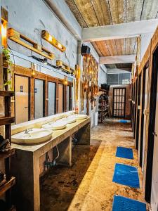 a bathroom with four sinks and a row of mirrors at TT Hostel in Vientiane