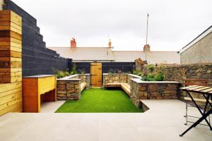 een patio met een tuin met groen gras bij LUXURY 4 Bedroom 4 Ensuite Home in Penarth (Pool Table Games Room & BBQ Garden) with Sea Views in Cardiff