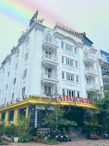 a large white building with a sign on it at Sapa Adam Hotel in Lao Cai