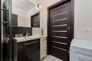 uma casa de banho com um lavatório e uma porta preta em Comfortable & Cozy Studio with Balcony - Klimasa by Renters em Breslávia