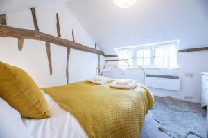a bedroom with a bed with towels on it at Lilac Cottage, Wenhaston in Halesworth