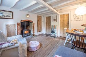 a living room with a couch and a fireplace at Lilac Cottage, Wenhaston in Halesworth
