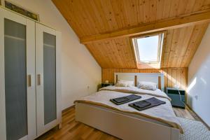 エゲルサロークにあるFekete Rigó Vendégházの木製の天井のベッドルーム1室(大型ベッド1台付)