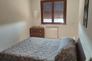 ein Schlafzimmer mit einem Bett, einer Kommode und einem Fenster in der Unterkunft PomeziaCity Apartment in Pomezia