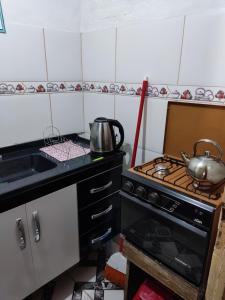 uma cozinha com um fogão e uma panela no balcão em Alojamiento Carol em Melo