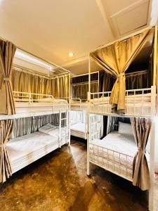 a room with three bunk beds in a room at TT Hostel in Vientiane