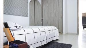 een slaapkamer met een bed met een witte deken bij Apartamento céntrico con suave cama y wifi gratuito! in Cali
