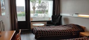 a hotel room with a bed and a table and a window at Hotel Cikada in Mariehamn