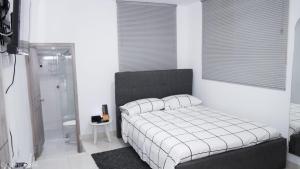 een slaapkamer met een bed en een badkamer met een douche bij Apartamento céntrico con suave cama y wifi gratuito! in Cali