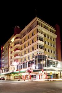 un grand bâtiment situé dans une rue de la ville la nuit dans l'établissement Kelvin Hotel, à Invercargill