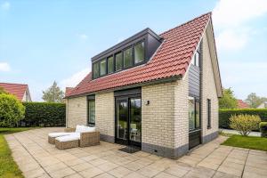 a house with a red roof on a patio at Kustverhuur, Park Schoneveld, Stern 204 in Breskens