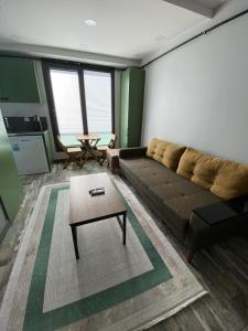 a living room with a couch and a coffee table at YOUR HOUSE Apart Otel in Karaköprü Köyü