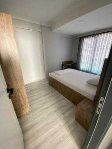 een kleine slaapkamer met een bed en een raam bij YOUR HOUSE Apart Otel in Karaköprü Köyü