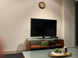 a flat screen tv sitting on top of a table at Spacious, Central 2 QB Melbourne CBD Apt near Flinders Stn, Town Hall in Melbourne