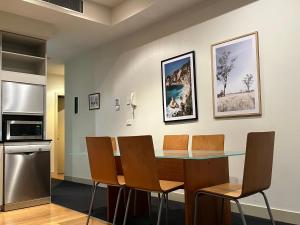 a kitchen and dining room with a table and chairs at Spacious, Central 2 QB Melbourne CBD Apt near Flinders Stn, Town Hall in Melbourne