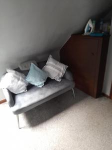 un sofá con almohadas en una habitación en Betty's retreat en Cheshunt