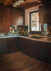 a kitchen with wooden cabinets and a window and a sink at Glamping Pod Gwiazdami in Pietrusza Wola