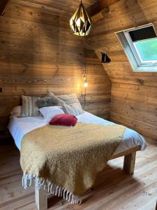 a bedroom with a bed in a room with wooden walls at chalet en montagne in Lées-Athas