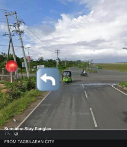 een auto die over een weg rijdt met een groene bij SUNSHINE STAY PANGLAO in Panglao