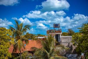 a resort with palm trees in front of a building at Pousada Ksa Zen Jeri in Jericoacoara