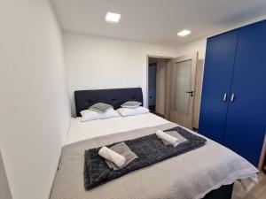 um quarto com uma cama grande com duas toalhas em POD OREHI - Hiša na podeželju - RAZPRŠENI HOTEL Jeruzalem Slovenija em Miklavž pri Ormožu