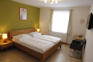 1 dormitorio con cama, ventana y TV en Gasthof Haselberger, en Marbach an der Donau