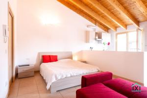 1 dormitorio con 1 cama y 1 sofá rojo en Travedona Loft by lake Ixihome, en Travedona