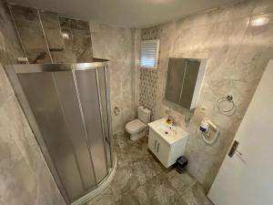 a bathroom with a shower and a toilet and a sink at Golden Gate Hotel Topkapı in Istanbul