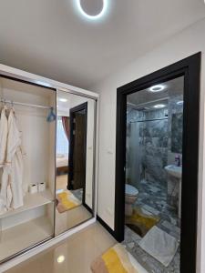 a bathroom with a toilet and a glass door at Phuket Airport Hotel at Mai Khao Beach in Ban Bo Sai Klang