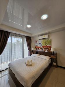 sypialnia z dużym łóżkiem z dwoma ręcznikami w obiekcie Phuket Airport Hotel at Mai Khao Beach w mieście Ban Bo Sai Klang