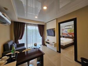 a living room with a bed and a mirror at Phuket Airport Hotel at Mai Khao Beach in Ban Bo Sai Klang