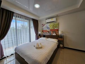 a bedroom with a bed with two slippers on it at Phuket Airport Hotel at Mai Khao Beach in Ban Bo Sai Klang