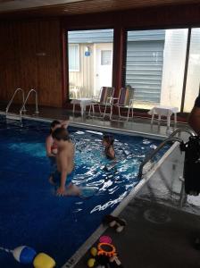 een groep kinderen die spelen in een zwembad bij Motel de l'anse in Port-Daniel