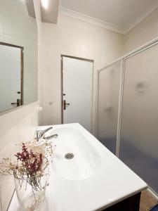 a white bathroom with a sink and a shower at Casa Bienvenida in Bienvenida