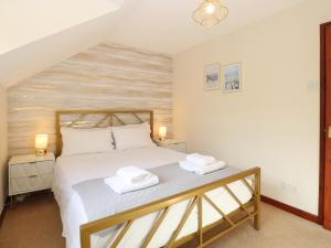 a bedroom with a bed with two towels on it at Seaview Cottage in Holt