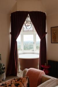 a bathroom with a large window and a bath tub at The Beacon in Royal Tunbridge Wells
