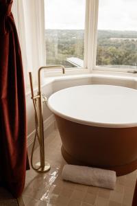 y baño con bañera y ventana. en The Beacon, en Royal Tunbridge Wells