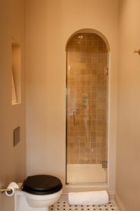 bagno con doccia e servizi igienici con sedile nero. di The Beacon a Royal Tunbridge Wells