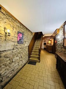 a staircase in a building with a stone wall at Auberge La Cléa in La Pesse