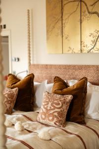 Una cama con almohadas marrones y blancas. en The Beacon en Royal Tunbridge Wells
