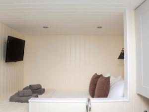 a bedroom with a bed and a tv on a wall at Hillside Hut in Ashbourne