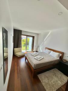 a bedroom with a bed and a chair and a window at River House Viana in Viana do Castelo