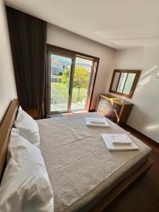 a bedroom with a large bed with a large window at River House Viana in Viana do Castelo