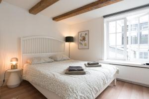 a bedroom with a white bed with two pillows on it at Apartments Romance in Amsterdam