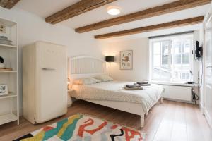 アムステルダムにあるApartments Romanceの小さなベッドルーム(ベッド1台、冷蔵庫付)