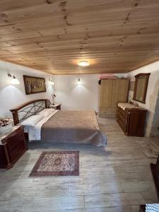 ein Schlafzimmer mit einem großen Bett und einer Holzdecke in der Unterkunft Tulip House in Yerakárion