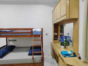 a room with two bunk beds and a desk at Cs Villa Homestay in Ipoh +112 photos