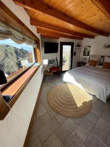 um quarto com uma cama grande e uma janela grande em Casa rural El Lomito em Tejeda