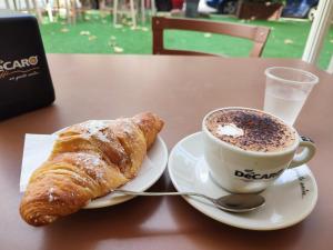 a cup of coffee and a croissant on a table at Room in Bloom Bed and Breakfast in Terlizzi
